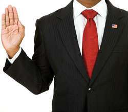 Photograph of a man taking an oath with right hand raised